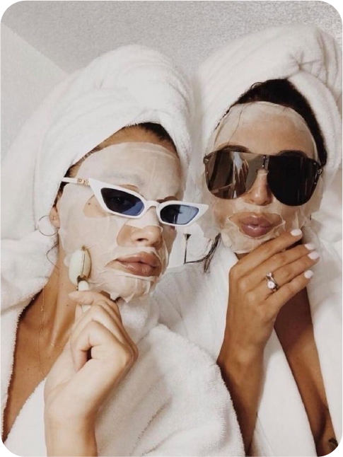 Two friends wearing sheet masks and sunglasses
