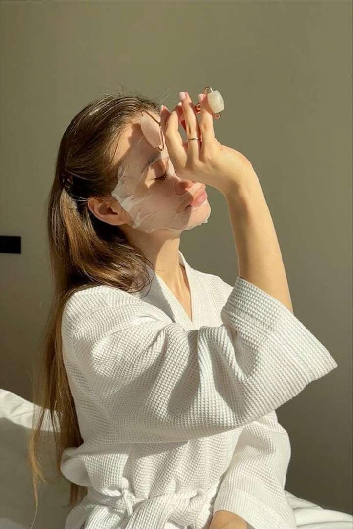 Woman wearing a sheet mask in warm natural light