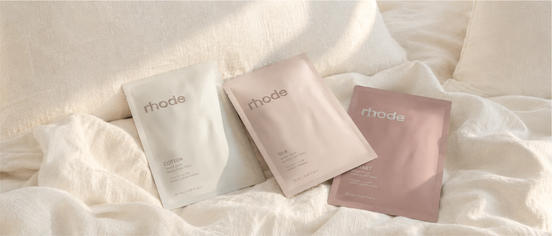 Cotton, Silk and Velvet Rhode sheet-mask concepts arranged on soft cream bedding