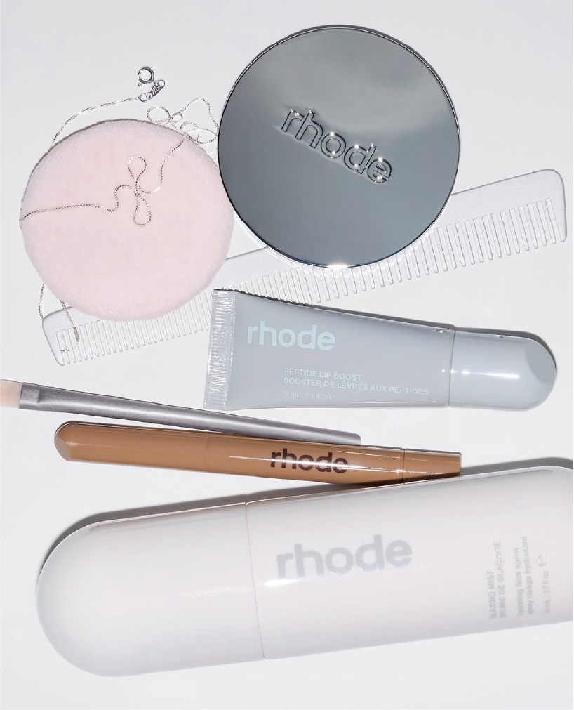 Existing Rhode skincare and beauty products arranged on a pale background